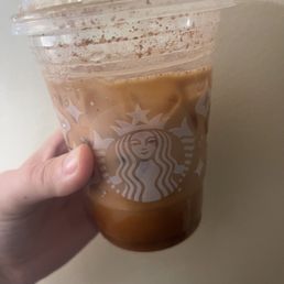 a hand holding a cup of iced coffee a hand holding a cup of iced coffee