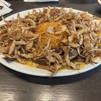 Mi Cocina - Combination (beef and chicken) fajitas Sunset Style (with spicy queso and topped with crispy fried onions) - Tex-Mex Near Me - Dallas, Texas Mi Cocina - Combination (beef and chicken) fajitas Sunset Style (with spicy queso and topped with crispy fried onions) - Tex-Mex Near Me - Dallas, Texas