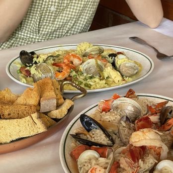 Perla Restaurant - a woman sitting at a table with plates of food - Portuguese Near Me - Toronto, Ontario Perla Restaurant - a woman sitting at a table with plates of food - Portuguese Near Me - Toronto, Ontario