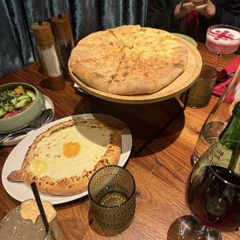 Deda Restaurant - Adjaruli and Imeruli khachapuri side by side -- rich, cheesy, perfectly baked, and meant for sharing. - Georgian Near Me - Pasadena, California Deda Restaurant - Adjaruli and Imeruli khachapuri side by side -- rich, cheesy, perfectly baked, and meant for sharing. - Georgian Near Me - Pasadena, California