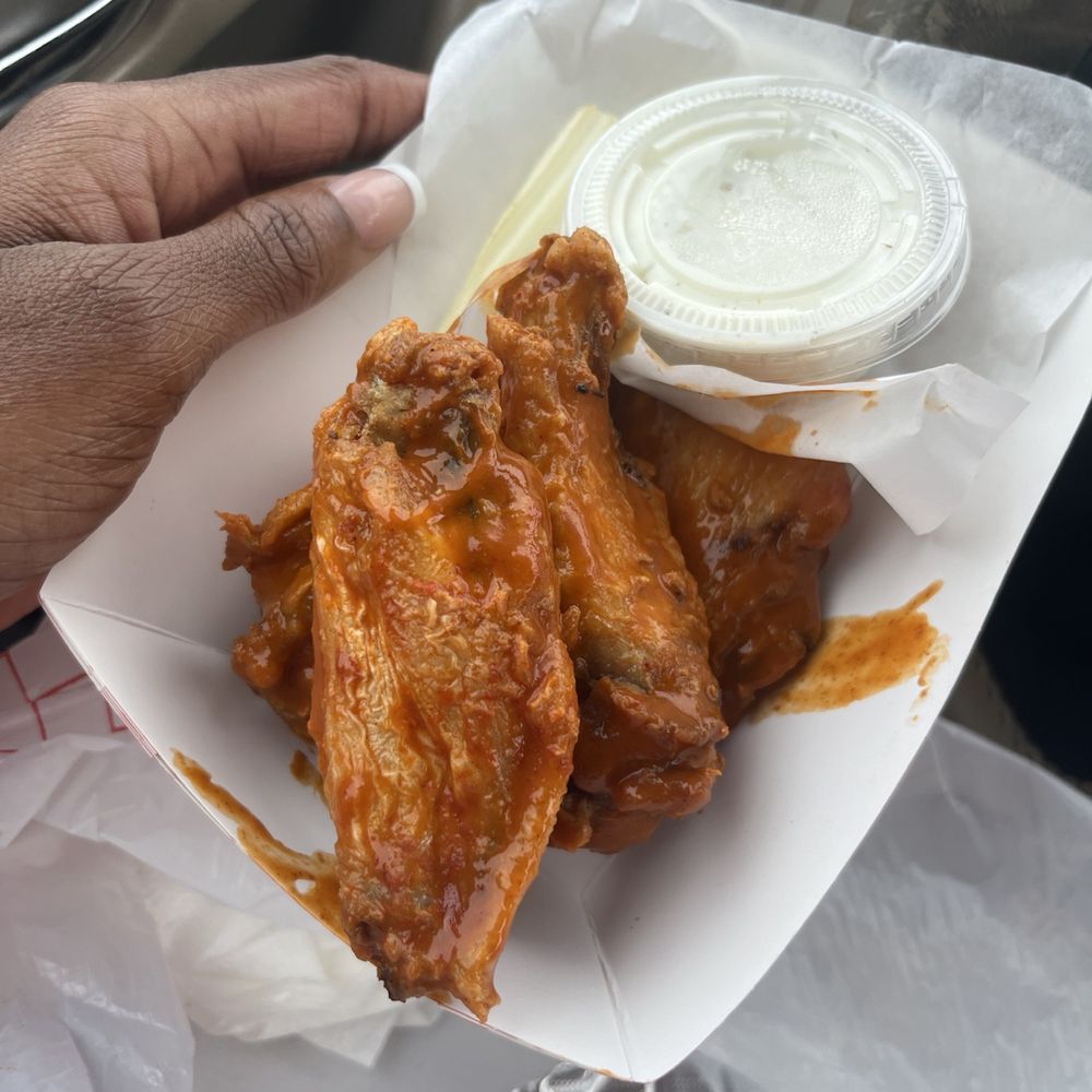 Double Ds Wings, Dogs & Goodness - a hand holding a basket of chicken wings - Food Trucks Near Me Double Ds Wings, Dogs & Goodness - a hand holding a basket of chicken wings - Food Trucks Near Me