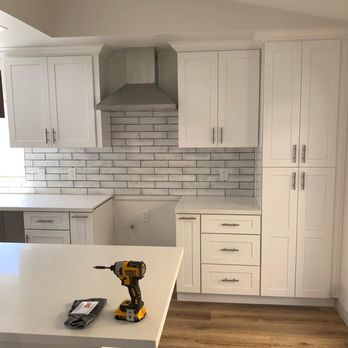 Prestigious - a kitchen with white cabinets and wood floors - Cabinetry Near Me Prestigious - a kitchen with white cabinets and wood floors - Cabinetry Near Me