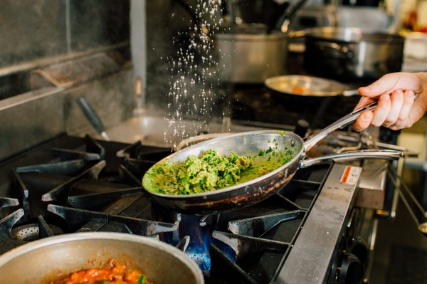 Photo of Due' Cucina Italiana - Capitol Hill - Seattle, WA, US. Chef preparing Kale Pesto pasta dish