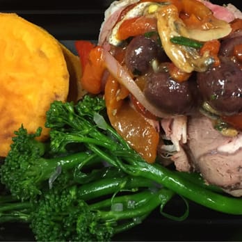 Caveman Chefs - Roasted leg of lamb with yams, broccolini, roasted red pepper, garlic, anchovy, and olives - Caterers Near Me