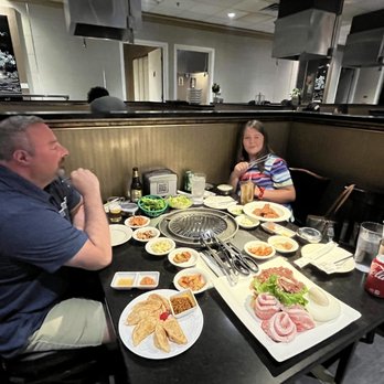 Seoul B.B.Q - Gun-Mandu at the bottom left of photo.Lettuce leaves. Small dishes of various banchan. Large platter of uncooked meat. - Korean Near Me - New Britain, Connecticut