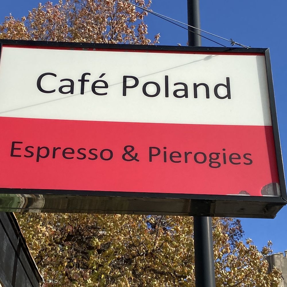 Café Poland - a red and white sign on a pole - Polish Near Me - Columbia, Missouri Café Poland - a red and white sign on a pole - Polish Near Me - Columbia, Missouri