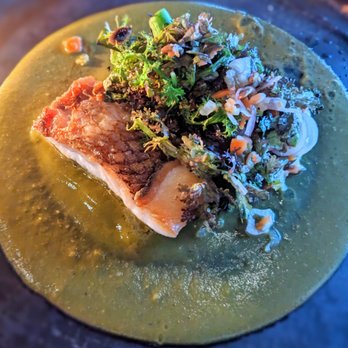 Claro - Mole Verde - Cooked fish served on a green sauce, garnished with fresh herbs and vegetables, in a restaurant setting. - Mexican Near Me - Brooklyn, New York