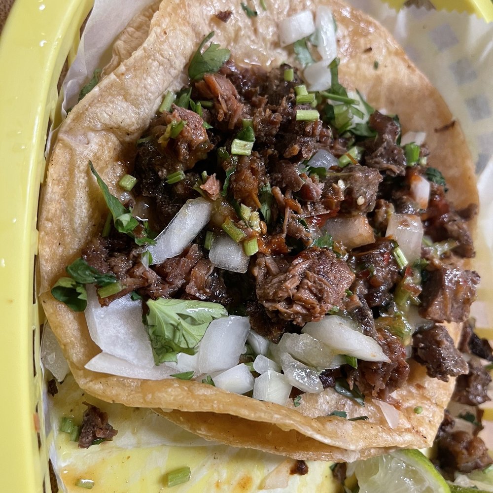 a plate of tacos and lime wedges a plate of tacos and lime wedges