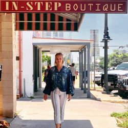 In-Step Fashions - The front of our store next to the entrance, showing our sign and a model in our clothing