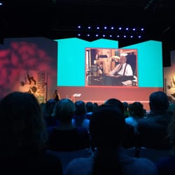 NBC Congrescentrum - De plenaire zaal met scherm en spreker.