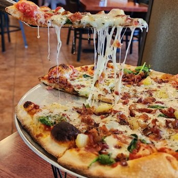 Trilogy Pizza & Wine - a slice being lifted by a spatula - Pizza Near Me - San Antonio, Texas