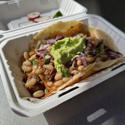 Perro Exquisite Taco - Perro taco - large carne asada taco with melted mild cheese, Peruvian beans, onion, cilantro, guac, etc