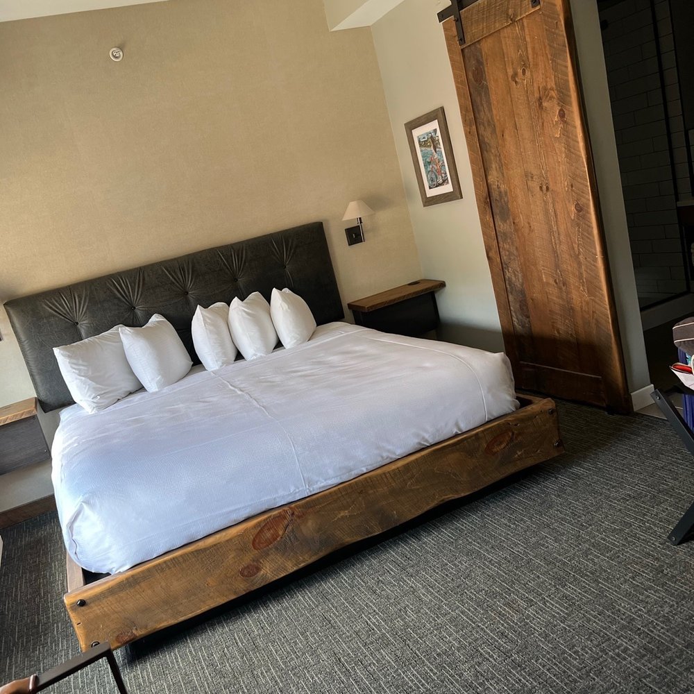 Hotel Crosby - a bedroom with a bed and a sliding door - Hotels Near Me - Stillwater, Minnesota