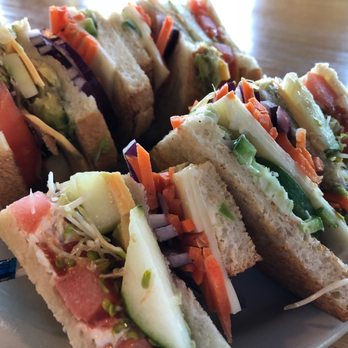 Steady Eddy's Cafe - 4 star veggie club on sour dough - A vegetable club sandwich with layers of fresh vegetables, including cucumbers, carrots, and sprouts, served on sliced bread. - Coffee & Tea Near Me - Flint, Michigan