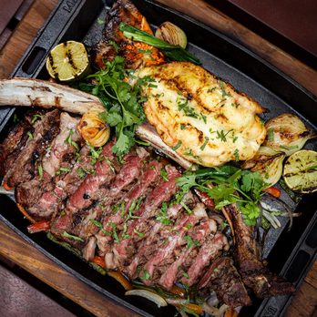 RED O - The Surf & Turf Tablita! 1 lb lobster tail, grilled 32 oz tomahawk chop, herb butter, sautéed peppers and onions, refried beans, red rice - Mexican Near Me - Thousand Oaks, California RED O - The Surf & Turf Tablita! 1 lb lobster tail, grilled 32 oz tomahawk chop, herb butter, sautéed peppers and onions, refried beans, red rice - Mexican Near Me - Thousand Oaks, California