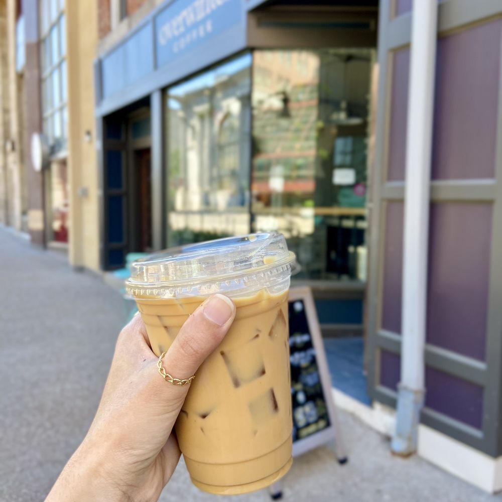Overwinter Coffee - a hand holding a cup of iced coffee - Coffee & Tea Near Me - Buffalo, New York Overwinter Coffee - a hand holding a cup of iced coffee - Coffee & Tea Near Me - Buffalo, New York