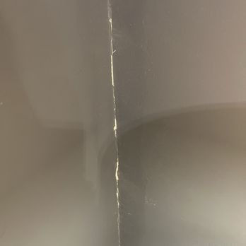 Bay State Bath - Cracked wall in bedroom that abuts bathroom - A photo showing a corner of a room with dark-colored walls, featuring a visible vertical crack along the corner. - General Contractors Near Me - Pembroke, Massachusetts