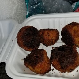 four pieces of fried food in a styrofoam container