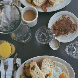 two egg breakfast with toast, fried potatoes for $15, bacon and apple chicken sausage for $3 extra each and crispy duck confit