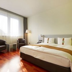 Hotel Holiday Inn - King-sized bed with window and seating