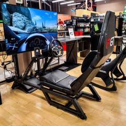 Electronic Express - Image of a racing simulation setup complete with large TV, simulation racing chair, steering where, and pedals.