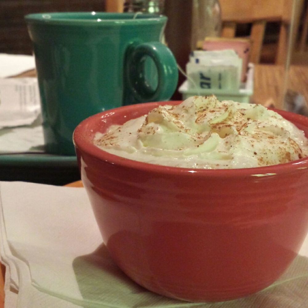Tomasita's - Warmed natillas pudding in front of cup of tea. - New Mexican Cuisine Near Me - Santa Fe, New Mexico Tomasita's - Warmed natillas pudding in front of cup of tea. - New Mexican Cuisine Near Me - Santa Fe, New Mexico