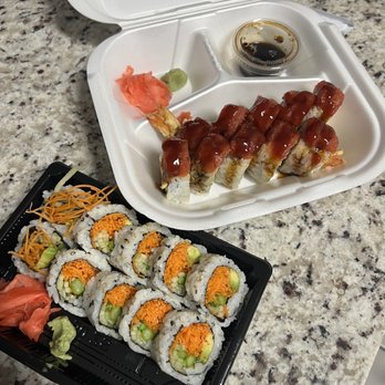 Sushi Corner - a tray of sushi and a container of sauce - Sushi Bars Near Me - Miami, Florida