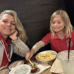 Enjoying our humus french fries, and pickles, at the kids table.