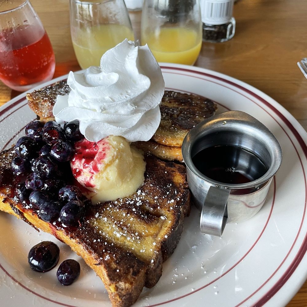 Cinnamon roll French toast and mimosa flight in the background Cinnamon roll French toast and mimosa flight in the background
