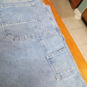 Boot Barn - Lee Dungys carpeter pants - Light blue denim carpenter pants with a back pocket and a side cargo pocket, placed on a wooden surface. - Shoe Stores Near Me - Janesville, Wisconsin