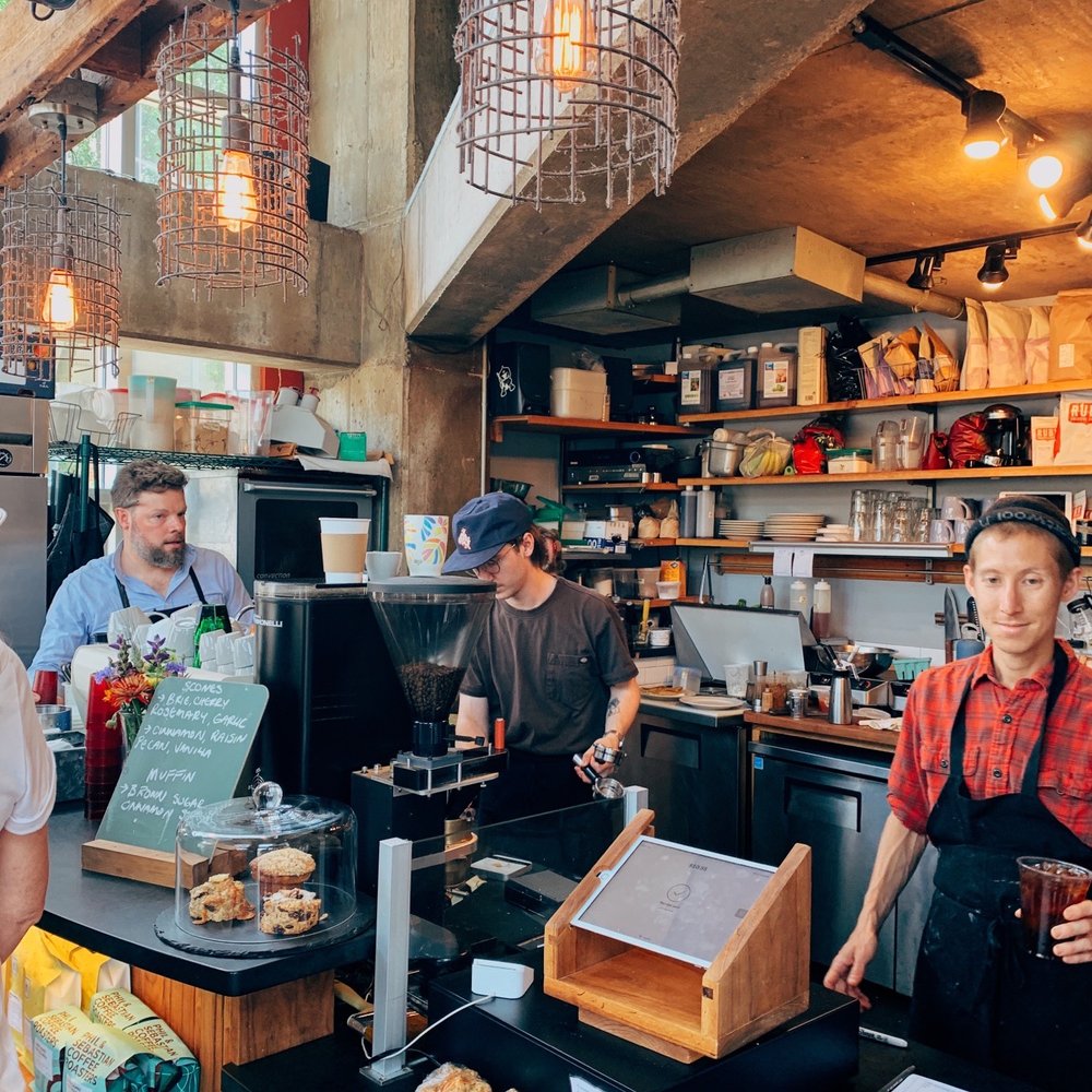 a group of people standing at a counter a group of people standing at a counter