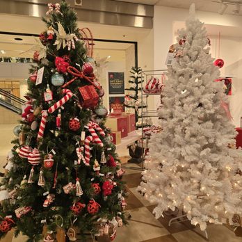 Macy's - Two Christmas trees, one decorated with red and white ornaments and the other white with lights, are displayed inside Macy's in Carlsbad, CA. - Department Stores Near Me - Carlsbad, California
