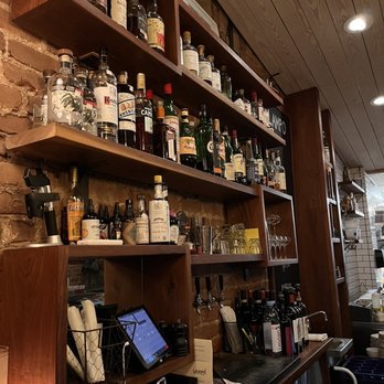Lampo - a shelf of liquor bottles on a brick wall - Italian Near Me - Charlottesville, Virginia Lampo - a shelf of liquor bottles on a brick wall - Italian Near Me - Charlottesville, Virginia