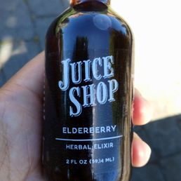 a hand holding a bottle of juice