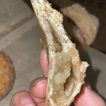Yates Cider Mill - a hand holding a half eaten doughnut - Donuts Near Me - Orion Township, Michigan