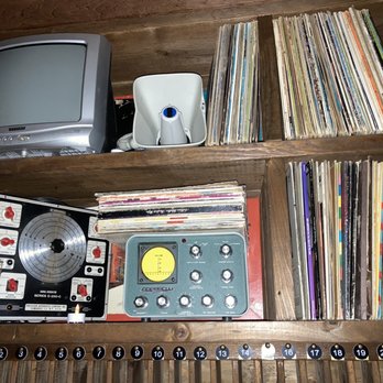 Midnight Market - a television, record player, cd player, and other items on a shelf - Lounges Near Me - Toronto, Ontario