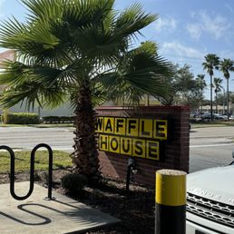 a palm tree in front of a sign a palm tree in front of a sign