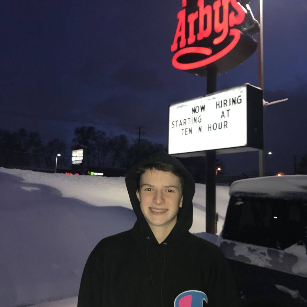 Arby's - a man standing in front of a sign - Fast Food Near Me - Midvale, Utah