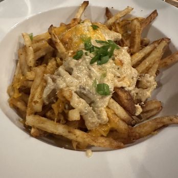 NaCl + H2O - Crab dip shrimp - French fries are topped with melted cheese, gravy, and chopped green onions, served in a white bowl at a restaurant. - Cocktail Bars Near Me - Rolla, Missouri