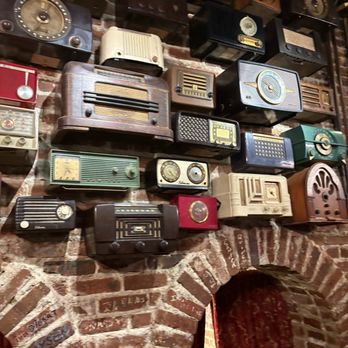Darryl's Wood Fired Grill - The cool wall behind me.  The wall of old radios - New American Near Me - Greensboro, North Carolina