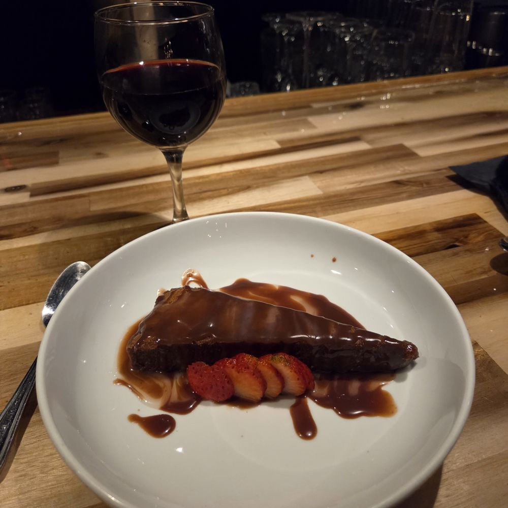 Flourless chocolate cake with caramel sauce and strawberries.