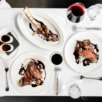Mooo.... Seaport - a table setting with steak, mushrooms, and wine - Steakhouses Near Me - Boston, Massachusetts