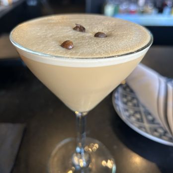 M’tucci’s Bar Roma - Espresso martini - A creamy espresso martini with a frothy top and coffee bean garnish served in a martini glass at a bar or restaurant. - Cocktail Bars Near Me - Albuquerque, New Mexico