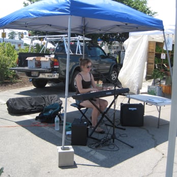 Dedham Farmers Market - a woman sitting under a blue tent - Farmers Market Near Me - Dedham, Massachusetts