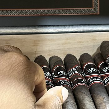 Burn One Cigar Lounge - a hand holding a cigar - Cigar Bars Near Me - Baltimore, Maryland Burn One Cigar Lounge - a hand holding a cigar - Cigar Bars Near Me - Baltimore, Maryland