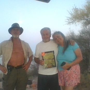 Cholla Campground - Hands, GOOD To Meet you and TINA  on journey of life ( Your song of the old days ( TREE TOP FLYER  https://www.youtube.com/watch?v=opBe5z0qw - Three people stand together outdoors in a desert environment with cacti and trees, with fog obscuring the background. One person holds a flyer, and the scene appears to be taken during early morning or late evening. The individuals are casually dressed, and the setting suggests a natural, outdoor location. - Campgrounds Near Me - Roosevelt, Arizona