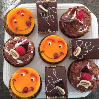 Schubert's Bakery - Mini cake. Smiley face is peach. Other round is tiramisu. Square is opera cake, chocolate - Bakeries Near Me - San Francisco, California Schubert's Bakery - Mini cake. Smiley face is peach. Other round is tiramisu. Square is opera cake, chocolate - Bakeries Near Me - San Francisco, California