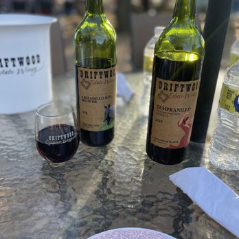 The Driftwood Bistro - a plate of food and two bottles of wine - Seafood Near Me - Driftwood, Texas