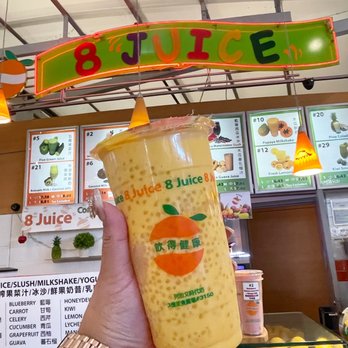 8 Juice - a person holding a drink in front of a fruit stand - Juice Bars & Smoothies Near Me - Richmond, British Columbia