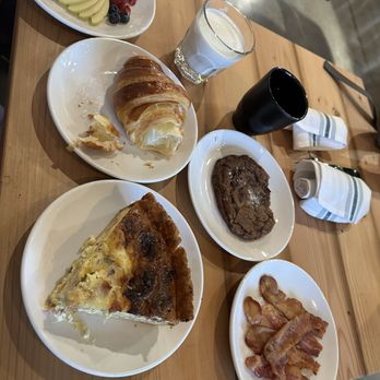 Three Hearts - Side fruit, croissant (partially eaten), chocolate chip cookie, side bacon, quiche. - Bakeries Near Me - Tacoma, Washington
